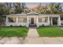 Charming home featuring a spacious front porch decorated with string lights and flowers at 907 Vistabula St, Lakeland, FL 33801