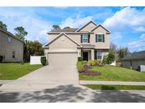 Charming two-story home with neutral paint, attached garage, manicured lawn, and beautiful landscaping at 1018 Roberta Rd, Lake Wales, FL 33853