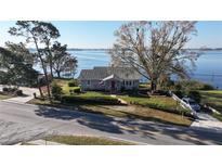 Charming gray home with a well-manicured front lawn and beautiful lake views at 1050 E Eagle Ave, Eagle Lake, FL 33839