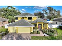 Charming two-story home with a well-manicured lawn and a three car garage and walkway to front door at 1904 Eloise Cove Dr, Winter Haven, FL 33884