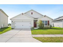 Charming single-story home with a well-maintained lawn and a two-car garage at 2759 Grandbury Grove Rd, Lakeland, FL 33811