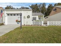 Charming single-story home featuring an attached garage, green lawn, and inviting curb appeal at 407 San Jose Dr, Winter Haven, FL 33884