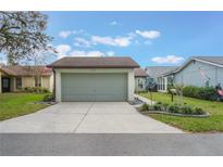 Attached two-car garage with a concrete driveway and well-maintained landscaping at 4422 Glenns Lndg, Winter Haven, FL 33884