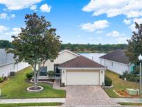 Charming single-story home with a two-car garage and lush landscaping, near a picturesque lake view at 496 Lake Suzanne Dr, Lake Wales, FL 33859