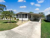 Well-maintained single-story home with a carport and a charming Florida room under a sunny blue sky at 6053 Southern Oaks Se Dr, Winter Haven, FL 33884