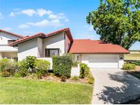 Charming home featuring a red tile roof, well-manicured lawn, and a two-car garage at 7016 Village Dr, Lake Wales, FL 33898