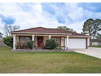 Charming single-story home features a well-manicured lawn, brick accents and a two-car garage at 125 Bergen Cir, Auburndale, FL 33823