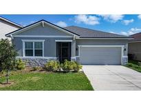 Charming single-story home featuring stone accents, manicured lawn, and a two-car garage at 153 Summershore Dr, Auburndale, FL 33823