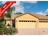 New construction home with a two-car garage, manicured landscaping, and a brick driveway at 1703 Linz Ct, Winter Haven, FL 33884