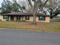 Charming one-story brick home featuring a well-maintained yard and mature trees at 2016 Amesbury Dr, Auburndale, FL 33823