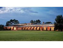 Expansive home exterior with a manicured lawn and warm interior lights at dusk at 2300 N Scenic Hwy # 120, Lake Wales, FL 33898