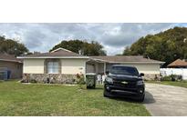 Charming single-story home featuring a stone accent facade, well-maintained lawn and a paved driveway at 2434 Mill Run Blvd, Kissimmee, FL 34744