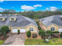 An aerial view of townhomes featuring brick driveways, attached garages, and manicured landscaping at 2723 Rutledge Ct, Winter Haven, FL 33884