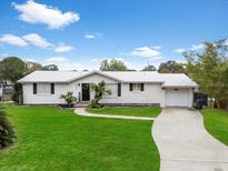 Charming single-story home featuring a bright, white brick exterior, manicured lawn, and a concrete driveway at 4024 Canal Rd, Lake Wales, FL 33898