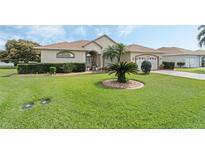Charming single-story home with a well-manicured lawn, mature landscaping, and a two-car garage at 415 Ruby Lake Pl, Winter Haven, FL 33884