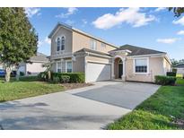 Charming two-story home featuring a well-manicured lawn and a paved driveway leading to the attached garage at 629 Copeland Dr, Haines City, FL 33844