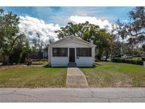 Quaint, one-story home featuring a traditional facade, screen front porch, and a walkway leading to the entrance at 750 Avenue O Sw, Winter Haven, FL 33880