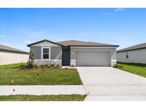 Charming single-Gathering home with a well-manicured lawn and a two-car garage at 1340 Oak Valley Drive, Auburndale, FL 33823