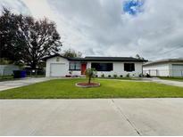 Charming single-story home with well-manicured lawn and a red front door at 1442 Gilmore Ave, Lakeland, FL 33805