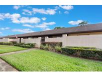 Exterior view of the condo community highlighting the well-maintained lawns and stucco privacy walls at 2254 Firestone Pl # 2254, Winter Haven, FL 33884