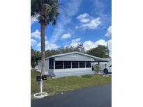 Charming single-story home with a screened-in porch and mature landscaping at 32 Berna Cir, Winter Haven, FL 33884