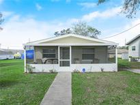 Charming single-story home featuring a screened porch with seating and well-maintained lawn at 343 Jewell St, Lake Wales, FL 33853