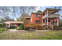 Charming two-story brick home with a wooden wheelchair ramp and a multi-tiered porch at 3655 N Scenic Hwy, Lake Wales, FL 33898