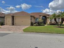 Charming single-story home featuring a well-manicured lawn, brick driveway, and a two-car garage at 5272 Pebble Beach Blvd, Winter Haven, FL 33884