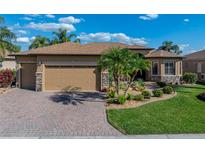 Charming home boasts a manicured lawn, brick driveway, and a two-car garage for a lovely curb appeal at 5357 Hogan Ln, Winter Haven, FL 33884