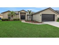 Charming single-story home with lush green lawn and attached two-car garage at 583 Drayton Rd, Winter Haven, FL 33884