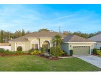 Charming single-story home with well-manicured lawn, lush landscaping, and a welcoming, covered entryway at 7327 Bent Grass Dr, Winter Haven, FL 33884