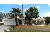 Charming single-story home featuring an attached garage, well-maintained lawn, and mature landscaping, creating curb appeal at 100 Heatherwood Blvd, Lake Wales, FL 33859