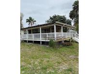 Charming single-story home with a covered front porch and white railing at 1405 N Lake Reedy Blvd, Frostproof, FL 33843