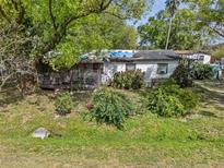Overgrown yard with small house and screen porch needing repair at 215 10Th Wahneta W St, Winter Haven, FL 33880