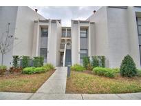Inviting condo exterior with well-maintained landscaping and a charming walkway to the entrance at 404 Laurel Cove Way # 404, Winter Haven, FL 33884