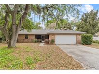 Charming brick home with a well-maintained lawn and mature trees providing ample shade at 4615 Reynosa Sw Dr, Winter Haven, FL 33880