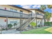 Exterior shot of a two-story building with well maintained landscaping and stairs leading to the second floor at 900 Avenue Z Se # A3, Winter Haven, FL 33880