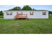 Charming single-story home featuring a cozy front porch and well-maintained lawn at 1302 Windsong Dr, Lakeland, FL 33811