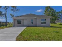 Charming single-story home featuring a well-maintained lawn and a concrete driveway at 225 Babson Dr, Babson Park, FL 33827
