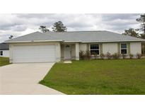 Inviting single-story home featuring a well-manicured lawn, attached two-car garage and neutral exterior at 2487 Sw 170Th Loop, Ocala, FL 34473