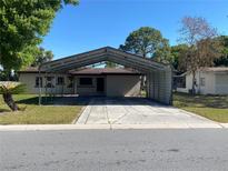 Charming single-story home with a carport and a well-maintained lawn in a quiet neighborhood at 2927 Walnut St, Winter Haven, FL 33881