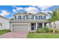 Charming two-story home features a well-manicured lawn, brick driveway, and eye-catching blue shutters at 3217 La Salle St, Winter Haven, FL 33884