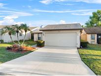 Charming single-story home with a two-car garage, lush landscaping, and well-manicured lawn at 4016 Cypress S Lndg, Winter Haven, FL 33884