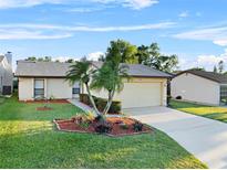 Charming single-story home featuring a well-manicured lawn and a two-car garage on a sunny day at 4016 Cypress S Lndg, Winter Haven, FL 33884