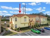 Inviting two-story townhome featuring a Spanish-tile roof and well-maintained landscaping in a neatly arranged community at 438 Monroe Cir, Davenport, FL 33896
