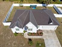 Beautiful aerial view of a charming home with a dark brown roof and a well-maintained lawn and full fence at 747 Fraser Ct, Kissimmee, FL 34759