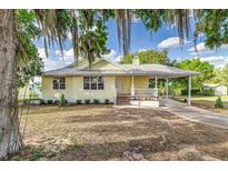 Charming yellow home featuring a metal roof and cozy front porch perfect for relaxing outdoors at 819 Seminole Rd, Babson Park, FL 33827