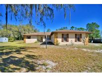 Charming single story home with stone accents, shuttered windows, and mature trees at 122 Wgto Tower Rd, Lake Alfred, FL 33850