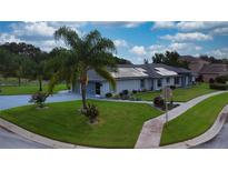 Charming single-story home with lush landscaping, solar panels, and a spacious driveway leading to a two-car garage at 217 Kent Ct, Haines City, FL 33844