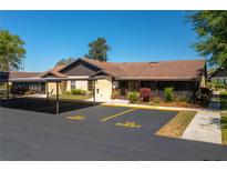 Charming single story home featuring a covered parking area and lush landscaping at 23 Kendra Ct, Winter Haven, FL 33880